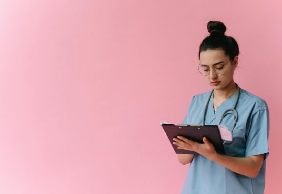 Nurse standing against pink background